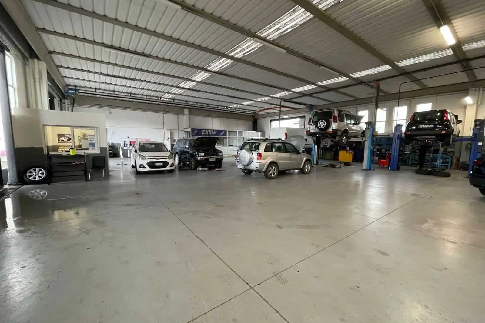 Interno officina con auto parcheggiate